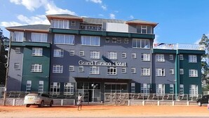 Un hôtel à plusieurs étages, reconnaissable à son grand panneau indiquant « Grand Turaco Hotel ».