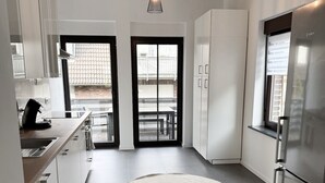 A modern kitchen with a round rug, stainless steel appliances, and a view to the outside. - Beautiful Apartment | Cologne | 15 min. Phantasialand (Hürth)
