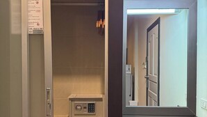 A hotel room with a minibar, a desk with a keyboard, and a mirror. - Superior King Room with Sofa & Balcony (Muang Pattaya)