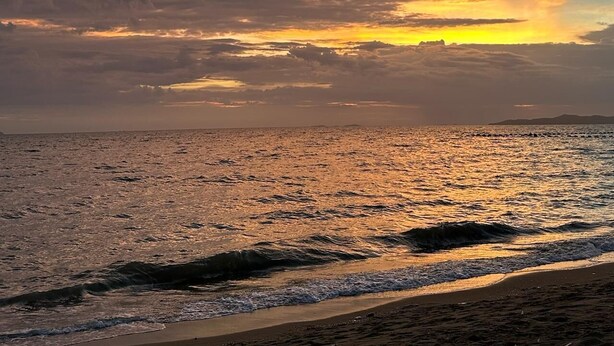 A beach with waves at sunset. - Superior King Room with Sofa & Balcony (Muang Pattaya)