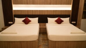 Ein Doppelzimmer mit Bett, Kopfstütze, zwei Kissen und einem gefalteten Handtuch auf jedem Bett.