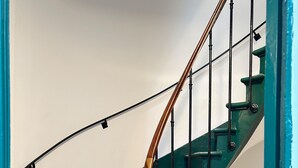 A spiral staircase with wooden steps and a metal railing.