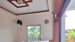Un mostrador de recepción moderno con detalles de madera, un amplio ventanal con vistas a la vegetación y un reloj en la pared.