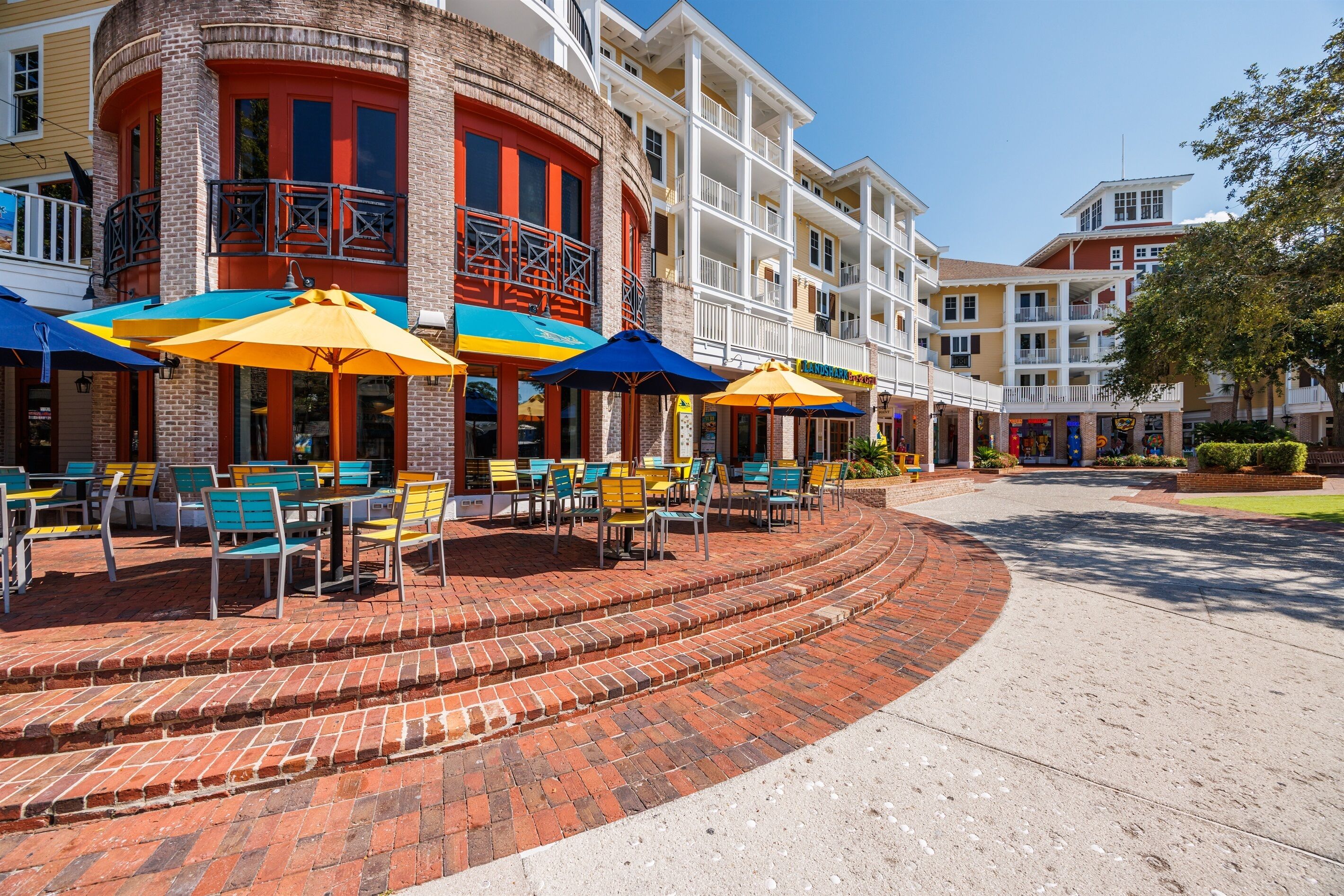 A hotel with outdoor seating and a brick patio.