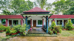 A traditional building with a red-tiled roof and a covered entrance.