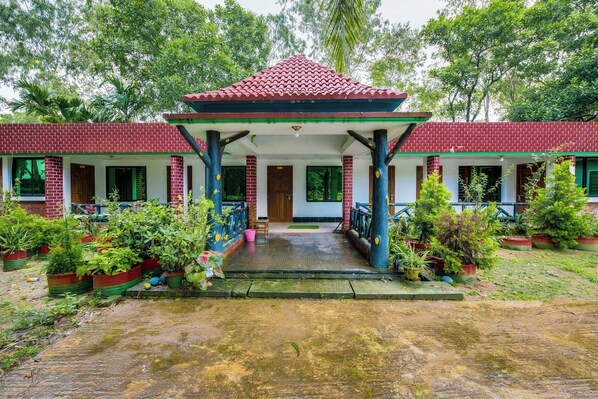 A traditional building with a red-tiled roof and a covered entrance. - Jaflong Green Resort (Gowainghat)
