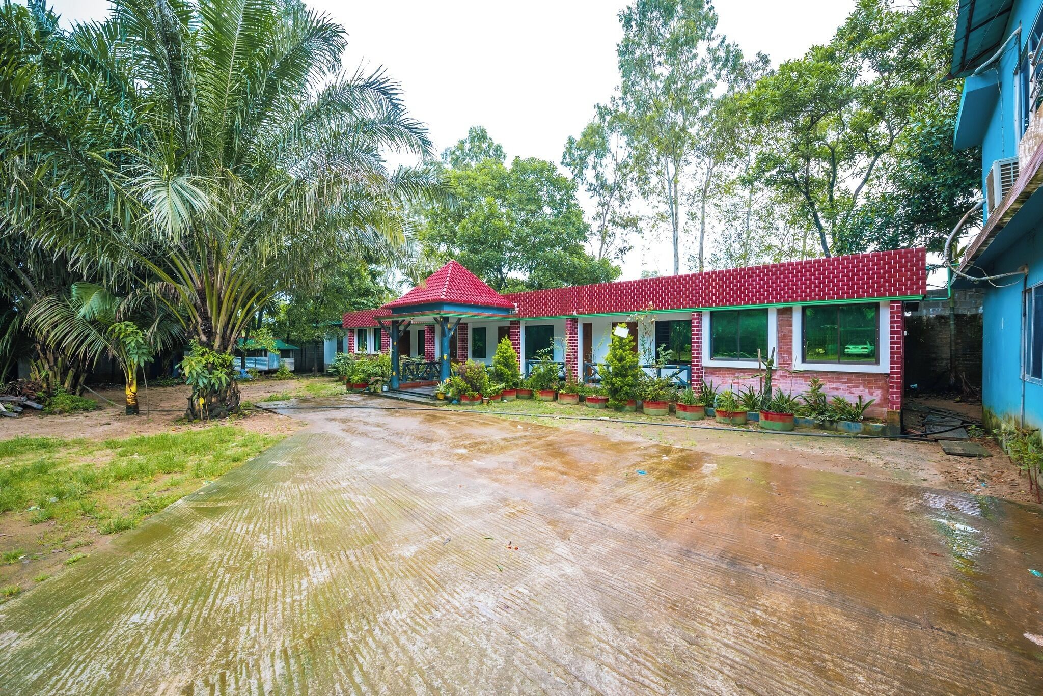 A red-brick building with a covered porch and potted plants.