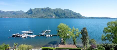 A marina with boats docked, surrounded by lush greenery and mountains in the background.