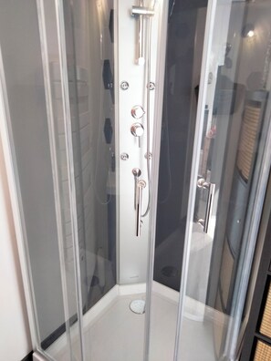 Een douche, handdoeken, zeep, toiletpapier