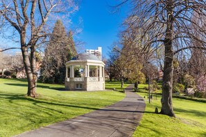 A gazebo in a park with a paved walkway leading to it.