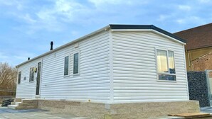 A single-story mobile home with a flat roof, a front door, and a small porch area. - Mobile home "Möwe am Geiseltalsee (Mücheln (Geiseltal))