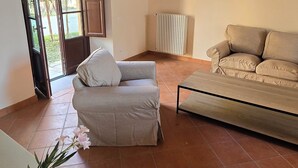 Amplia sala de estar con techo abovedado, un sofá, una mesa y vistas a través de un ventanal.