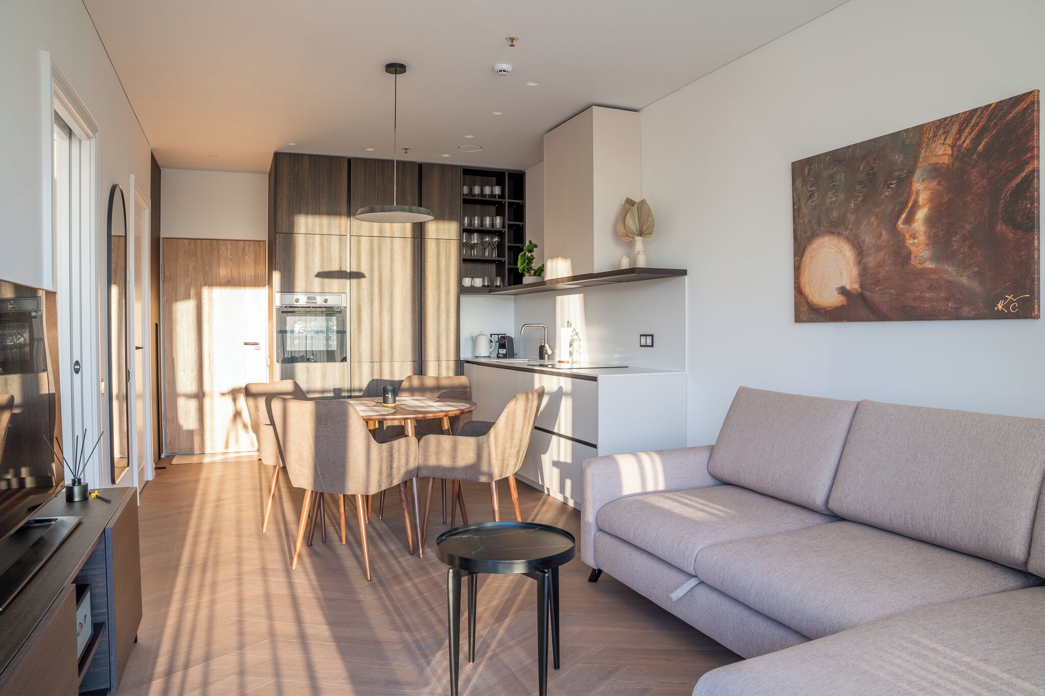 Una sala de estar moderna con sofá, comedor y cocina.