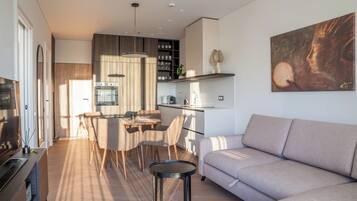 Una sala de estar moderna con sofá, comedor y cocina.