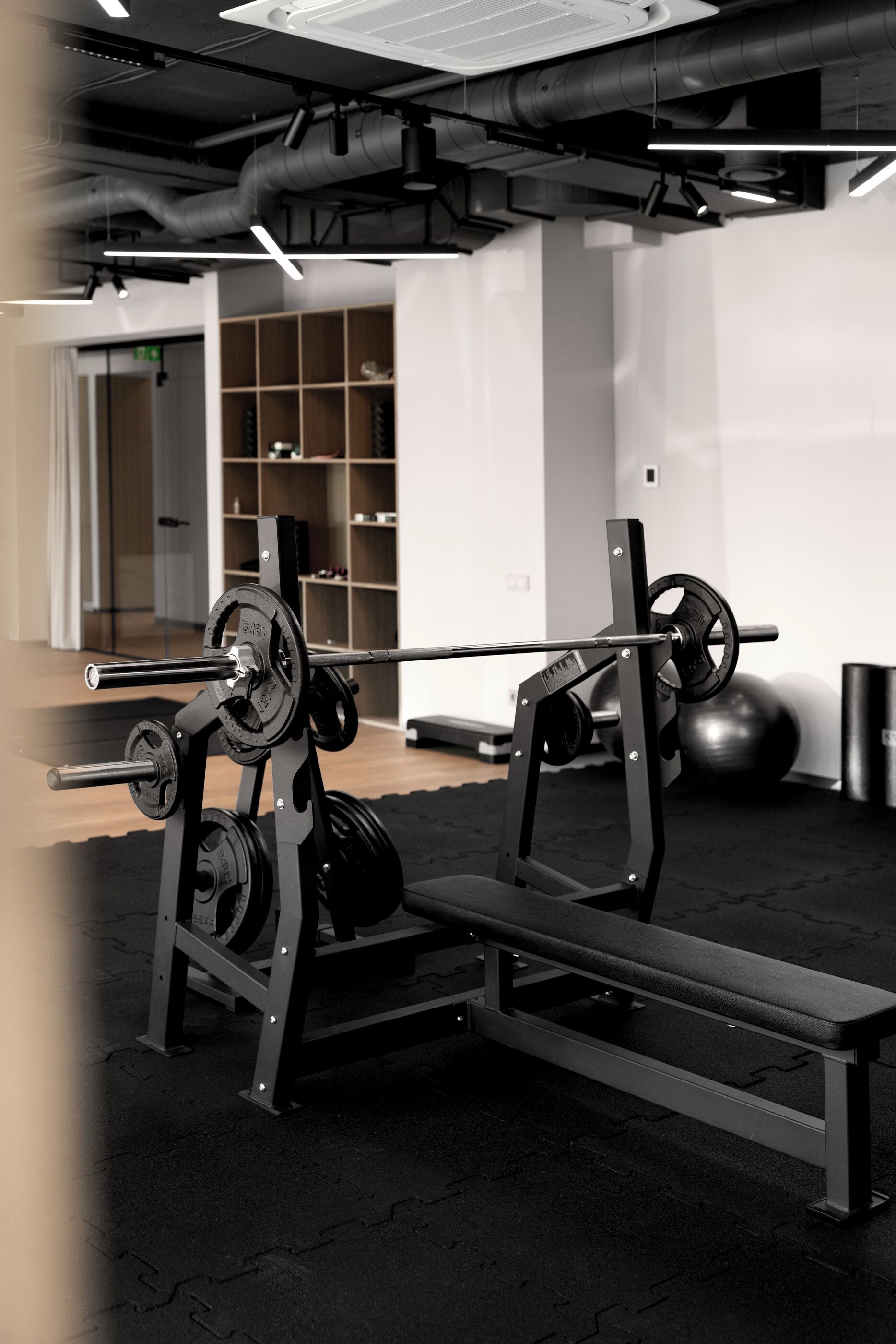 Et fitnessrum med vægtløfterbænk, vægtstang og vægtskiver.