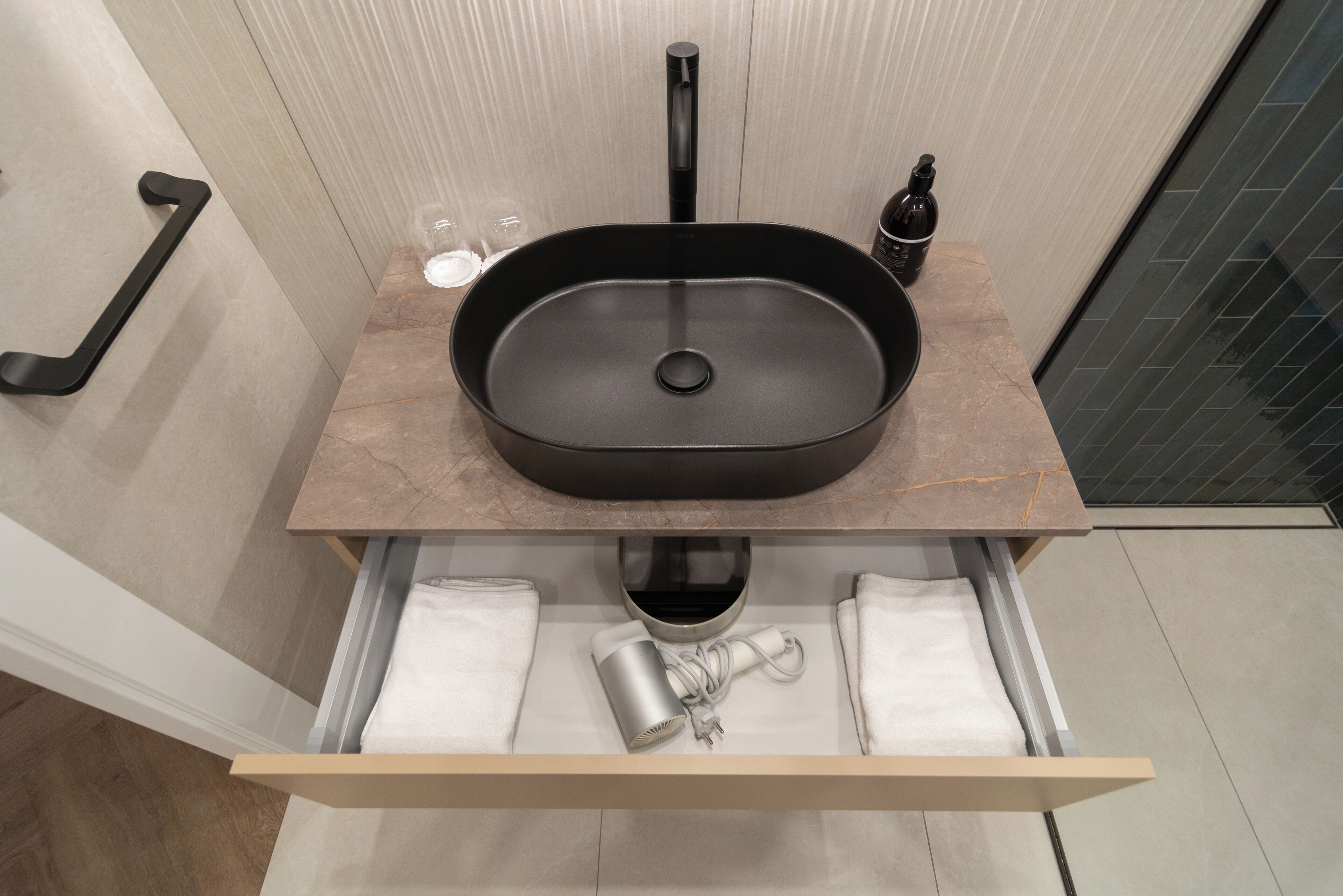 A bathroom with a modern sink, a towel rack, and a towel warmer.