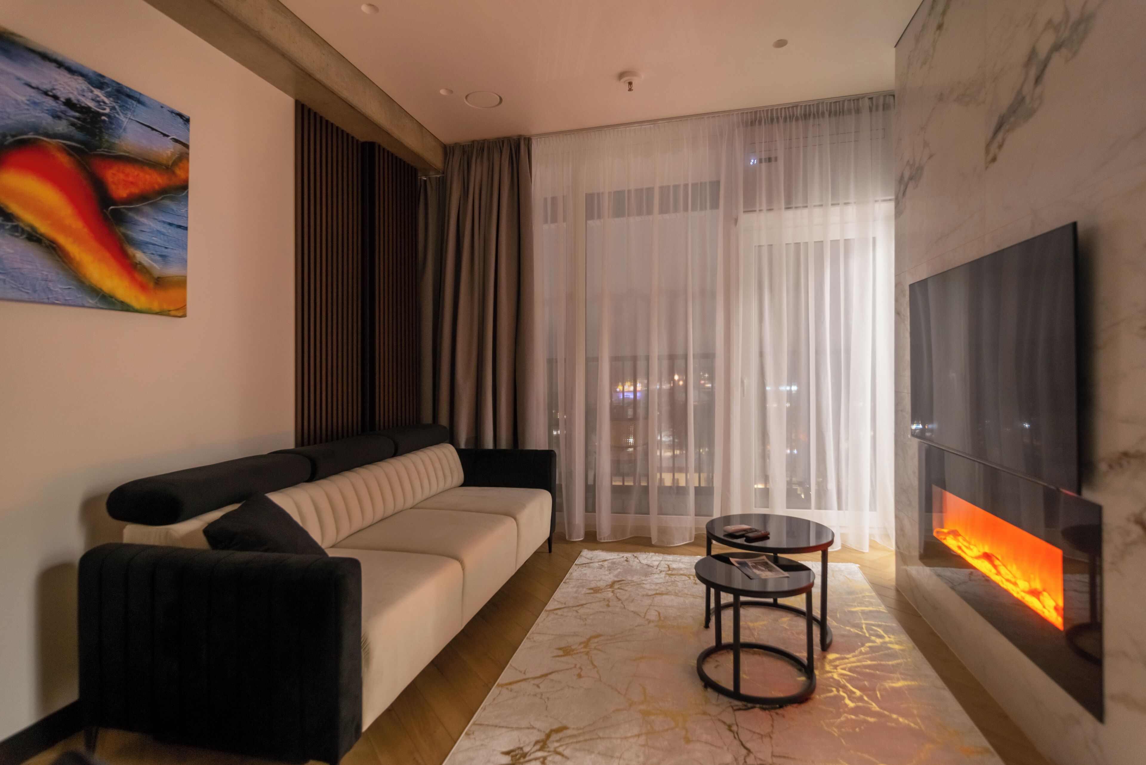 Una sala de estar moderna con un sofá, un televisor y una chimenea.