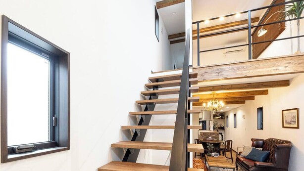 A modern staircase with wooden steps and metal railings leading to a lofted living area with a sofa and dining table. - Villa for rent for up to 10 people [Antiques Gifu Station East] 10 min. walk from JR Gifu Station (岐阜市)
