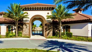 A building with a central archway, surrounded by palm trees and a clear blue sky. - 20 min to Disney , Epic , Star Wars , Gameroom ,Pool Luxe dw7 (Davenport)