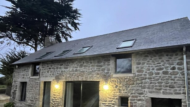 A stone building with a sloped roof, multiple windows, and a gravel driveway. - Cozy house in Montfarville, near Saint-Vaast-la-Hougue (Montfarville)