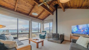 Un salon spacieux doté d’un grand téléviseur, de sièges confortables et offrant une vue sur les montagnes.