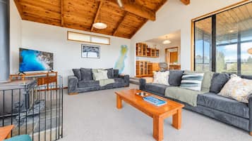 A modern living room with a fireplace, two sofas, a coffee table, and a TV.