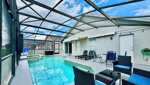 Uma área de piscina coberta com espreguiçadeiras e uma cesta de basquete.