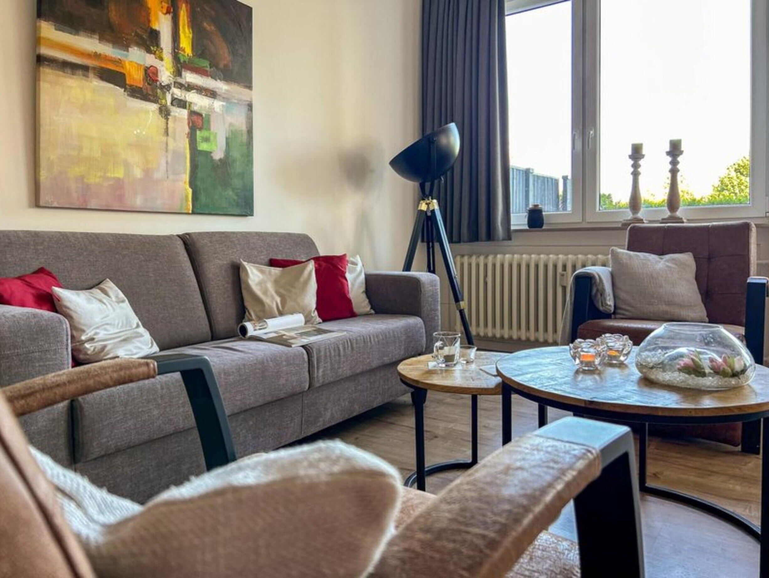 A modern living room with a grey sofa, a round coffee table, and a floor lamp.