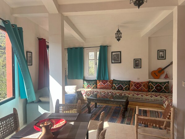 A cozy living room with a sofa, a wooden table, and a guitar.