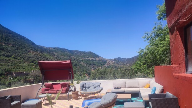 A terrace with outdoor seating, including a sofa, chairs, and a table, overlooking a mountainous landscape. - Chez Yahia, in the heart of Ourika, apartment with panoramic view (Ourika)