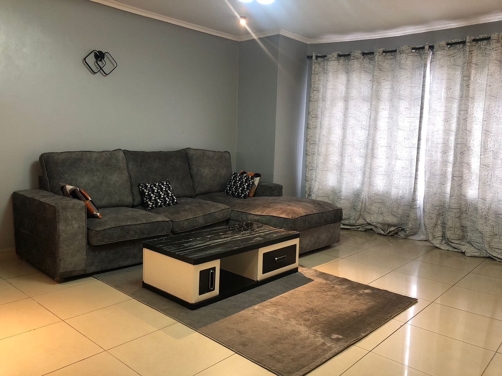A living room with a grey sofa, a coffee table, and a rug.