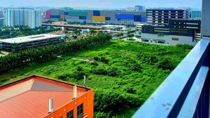Un paisaje urbano con edificios modernos, un parque verde y un edificio rojo en primer plano.