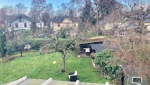 A residential area with houses, a grassy yard, and a tree with a swing. - Vacation apartment near Volkspark, arenas / Trabrennbahn /DESY (Hamburg)
