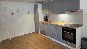 A modern kitchen with grey cabinets, a wooden countertop, and a built-in oven. - Vacation apartment "Sandra" in Denmark  (Bredebro)