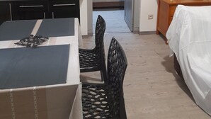Ett kompakt hotellrum med ett litet kök, en säng, ett matbord och en stol.