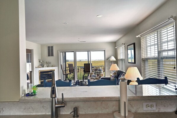 A spacious kitchen with a large window, a fireplace, and a view of the outdoors.