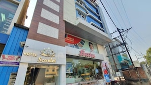 A hotel named 'Scarlet' with a visible entrance and a sign for 'Delhi Florist' across the street. - Hotel Scarlet (Gwalior)