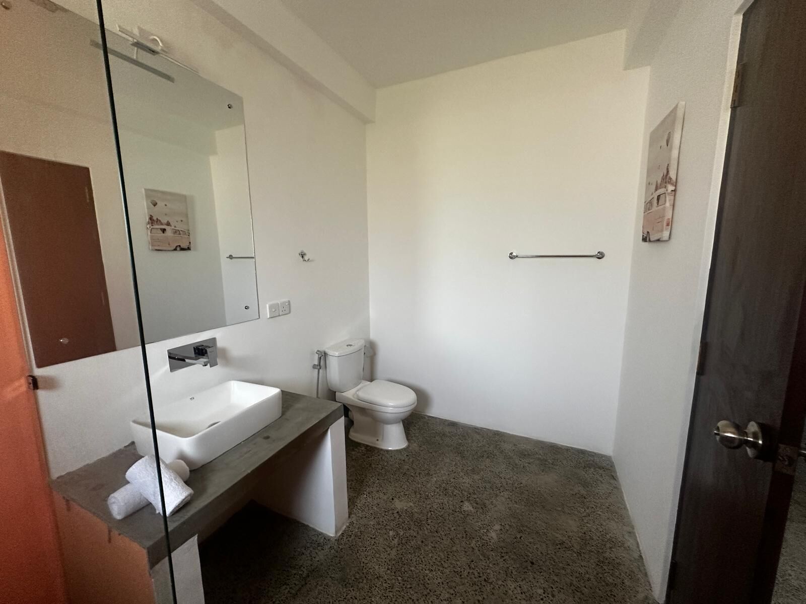 A bathroom with a white sink, toilet, and a towel rack.
