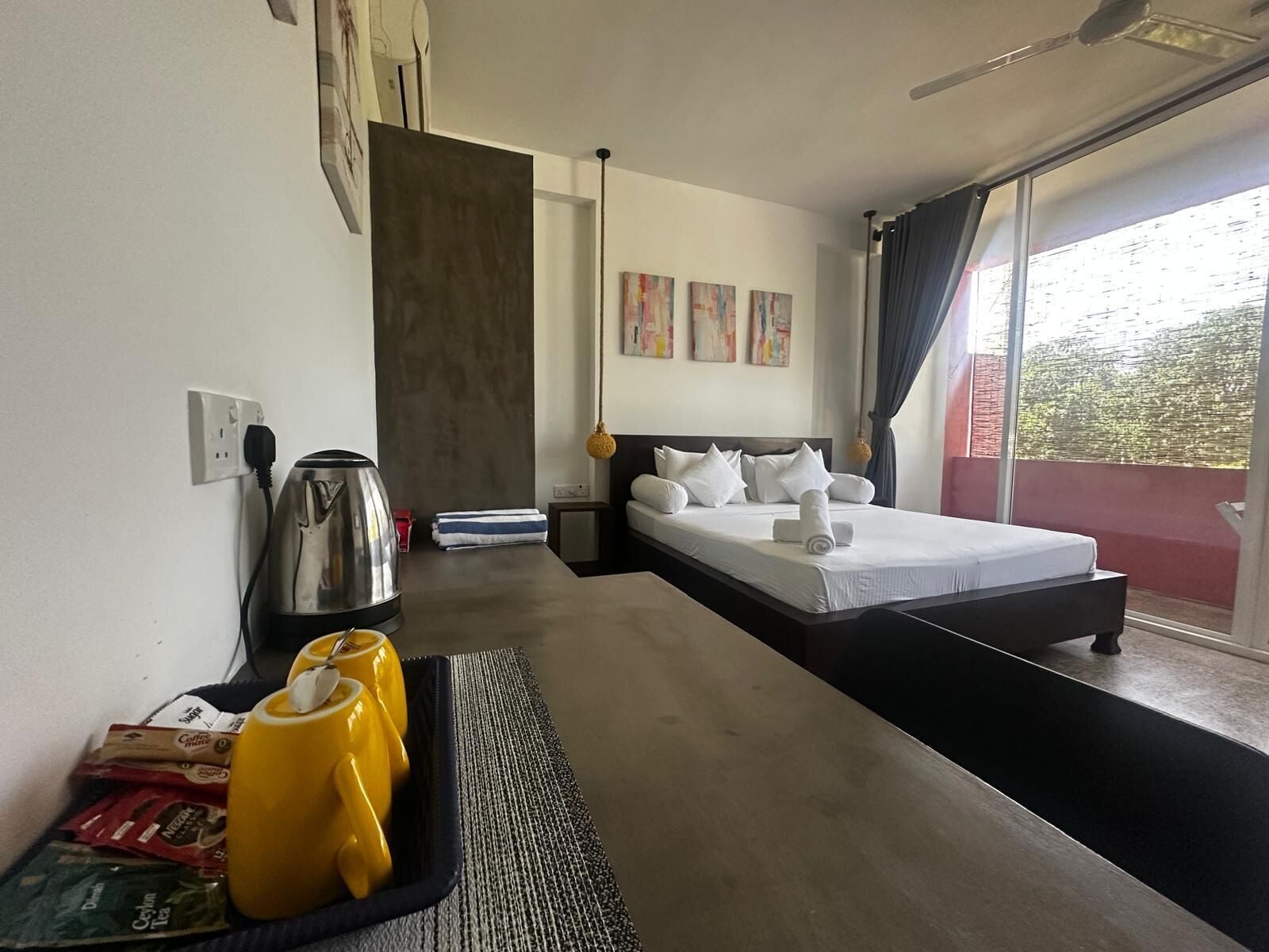Una habitación de hotel con cama, cafetera y una bandeja con cápsulas de café.