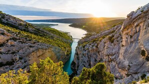 Eine Schlucht mit Fluss, Brücke und Berglandschaft.