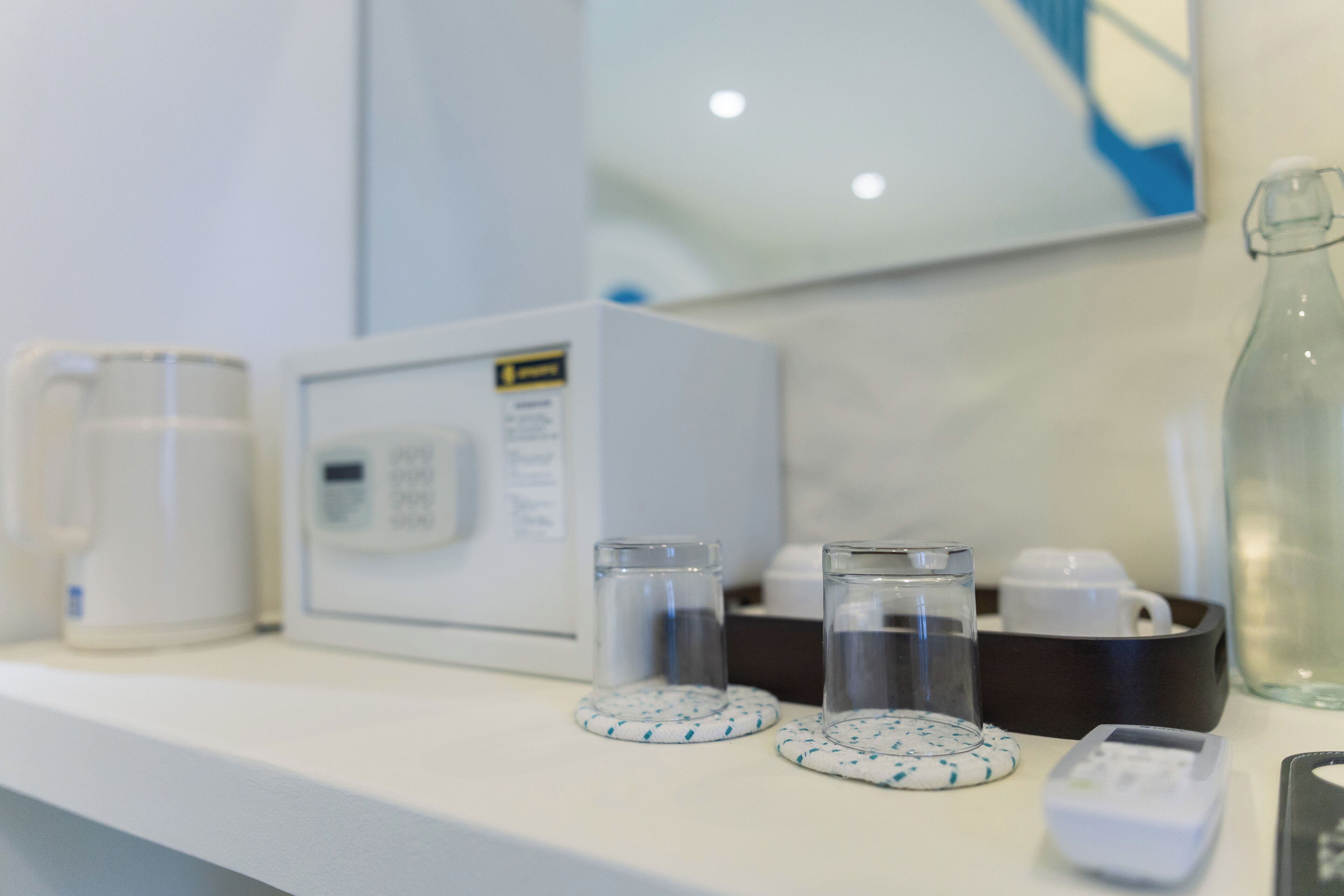 Habitación de hotel con microondas, cafetera y una botella de agua sobre la encimera.