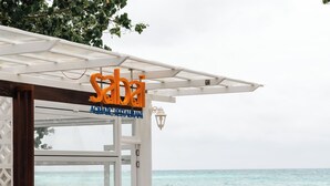 A beachside restaurant with outdoor seating and a view of the ocean. - Endorphins Beach Villa (Dhiffushi)