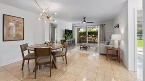 Un'ampia zona giorno con tavolo da pranzo, sedie, divano e televisore.