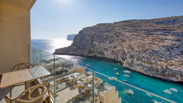 A balcony with a clear view of the sea and rocky cliffs. - Stylish Apartment - Breathtaking Views in Xlendi (Munxar)