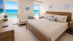 A bedroom with a large bed, a nightstand, a bedside table, a chair, and a view of the ocean. - Renovated 2 Bed, 2 Bath, Beachfront w/ Gulf views (Longboat Key)
