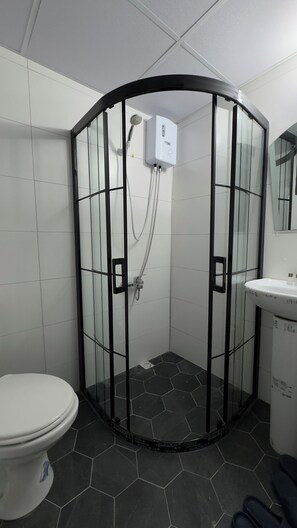 A bathroom with a glass-enclosed shower, a toilet, and a sink. - TERAS GARDEN BUNGALOV HATAY (Altınözü)