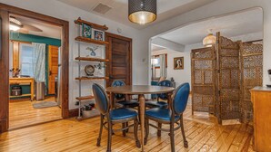 A dining area with a round wooden table and blue upholstered chairs. - Fresh Coast Craftsman - Pet Friendly | Near Lake (Sheboygan)