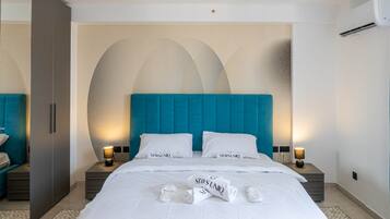 A hotel room with a large bed, two bedside tables, a wardrobe, and a wall with a geometric design.