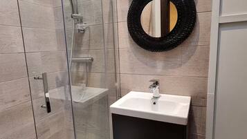 Een douche, een haardroger, handdoeken, toiletpapier