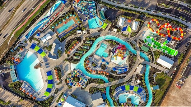 An aerial view of a water park with multiple pools, slides, and a winding water ride. - Luxury 6BR • Heated Pool Included • Theater •Disney • H2O Perks • No Resort Fees (Kissimmee)
